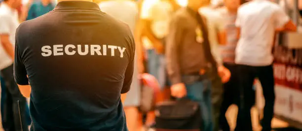 garde de sécurité dans un festival, restant immobile devant la foule